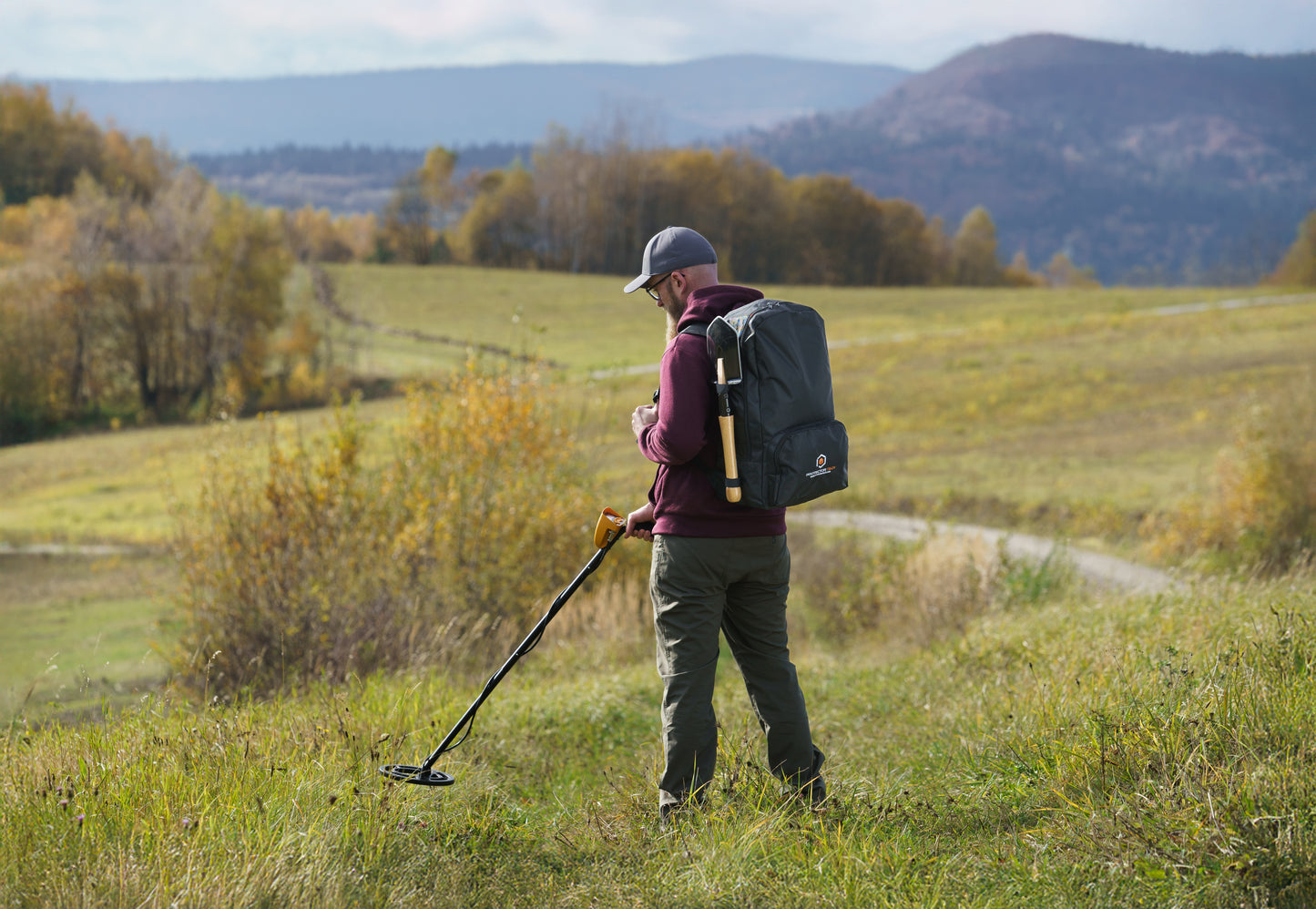 A backpack for a metal detector with a shovel attachment