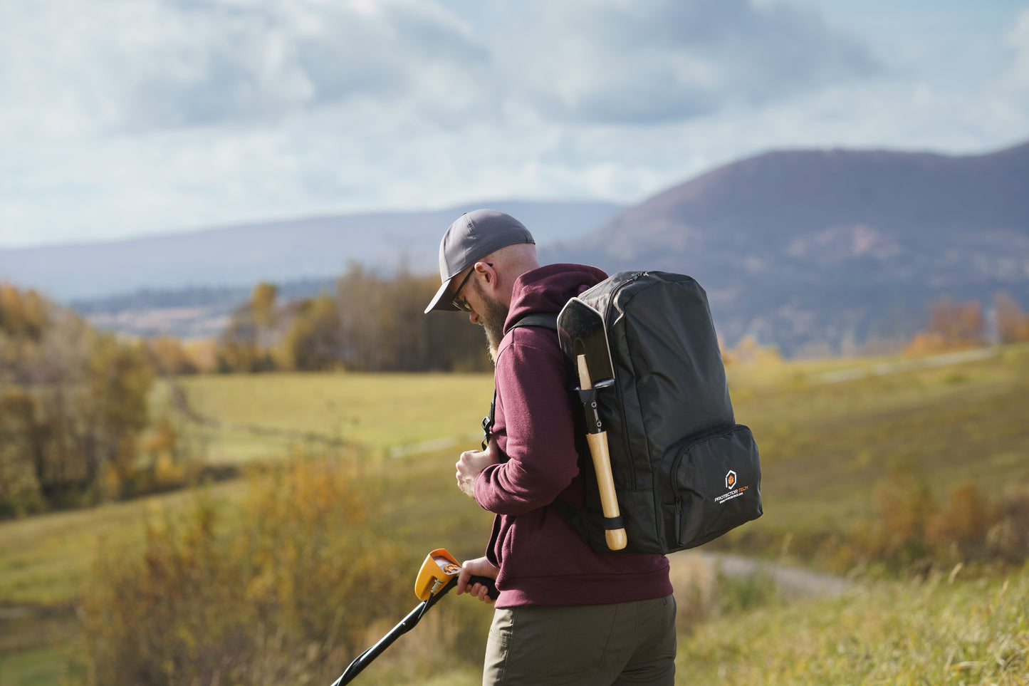 A backpack for a metal detector with a shovel attachment